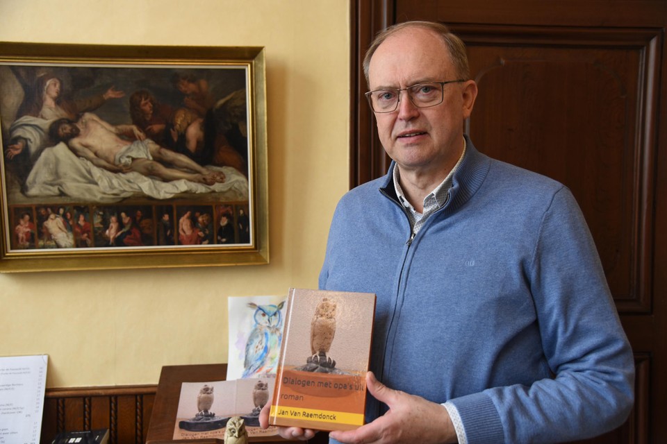 Jan poseert met boek Dialogen met opa's uil voor krantenartikel